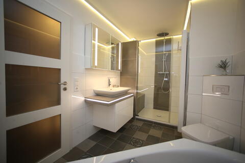 Badezimmer mit Lichtakzenten an Möbeln und Wänden