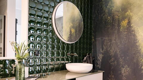 Badezimmer mit Tapete mit Waldaufdruck und grünen Fliesen