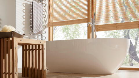 Badezimmer mit Holzhocker und Badewanne