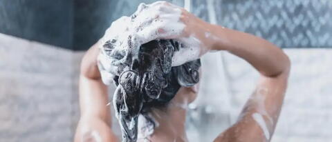 Frau wäscht sich die Haare