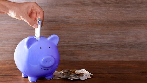 Hand befüllt Sparschwein