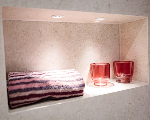 Beleuchtete Wandnische mit Kerzen und Handtüchern