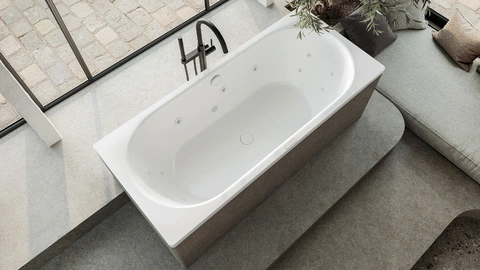 Aufnahme von oben von einer Badewanne im mediterranen Stil mit einer freistehenden Armatur aus Edelstahl