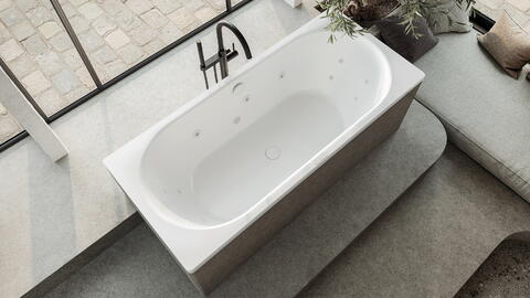 Aufnahme von oben von einer Badewanne im mediterranen Stil mit einer freistehenden Armatur aus Edelstahl