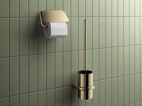 Elegant inszenierter Toilettenpapierhalter und WC-Bürstenset in glänzend goldener Ausführung vor einer edlen grün gekachelten Wand – ein luxuriös gestaltetes Detail in einem modernen Badezimmer/ HEWI/ S 480