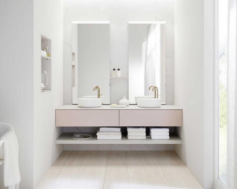 Rosafarbene Badunterschränke in einem weißen Bad