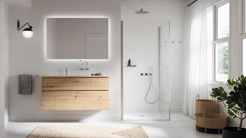 Helles Badezimmer mit einer bodengleichen Dusche, beleuchtetem Spiegel und Holz-Unterschrank