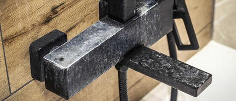 Schwarze Duscharmatur mit starker Kalkablagerung