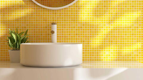 Gelb geflieste Badezimmerwand mit einem runden Waschbecken davor und einer kleinen grünen Pflanze daneben