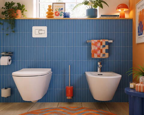 Toilette und Bidet vor einer blau gefliesten Wand mit Dekoartikel im Dopamine-Decor Stil