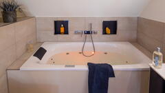 Gemütliches Badezimmer mit gefüllter Badewanne