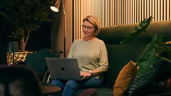 Frau sitzt auf dem Sofa mit Laptop