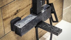 Schwarze Duscharmatur mit starker Kalkablagerung